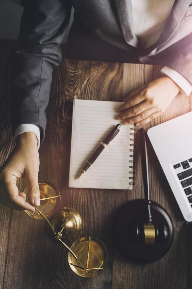 Business and lawyers discussing contract papers with brass scale on desk in office. Law, legal services, advice, justice and law concept picture with film grain effect photo