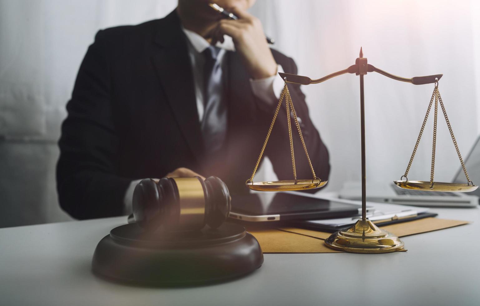 Business and lawyers discussing contract papers with brass scale on desk in office. Law, legal services, advice, justice and law concept picture with film grain effect photo