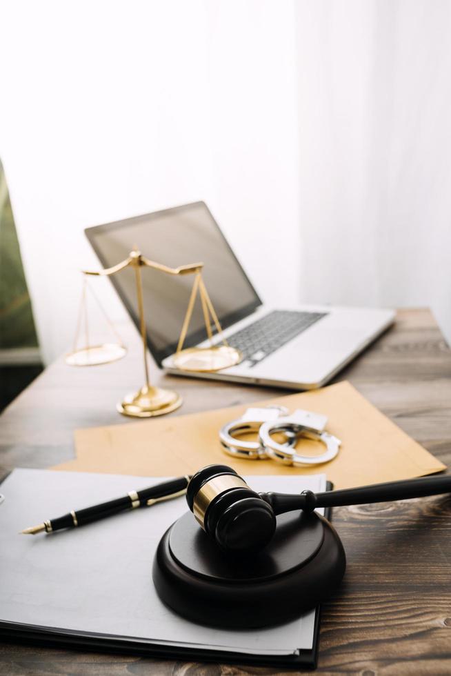 Business and lawyers discussing contract papers with brass scale on desk in office. Law, legal services, advice, justice and law concept picture with film grain effect photo