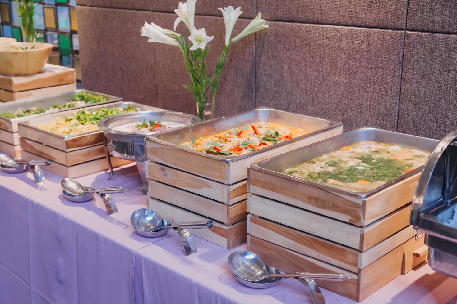 arreglo floral para la boda de verano, hecho de rosas y ramas verdes en una mesa en el restaurante. , vidrio y platos en el restaurante al aire libre en un día ventoso con efecto de grano de película foto