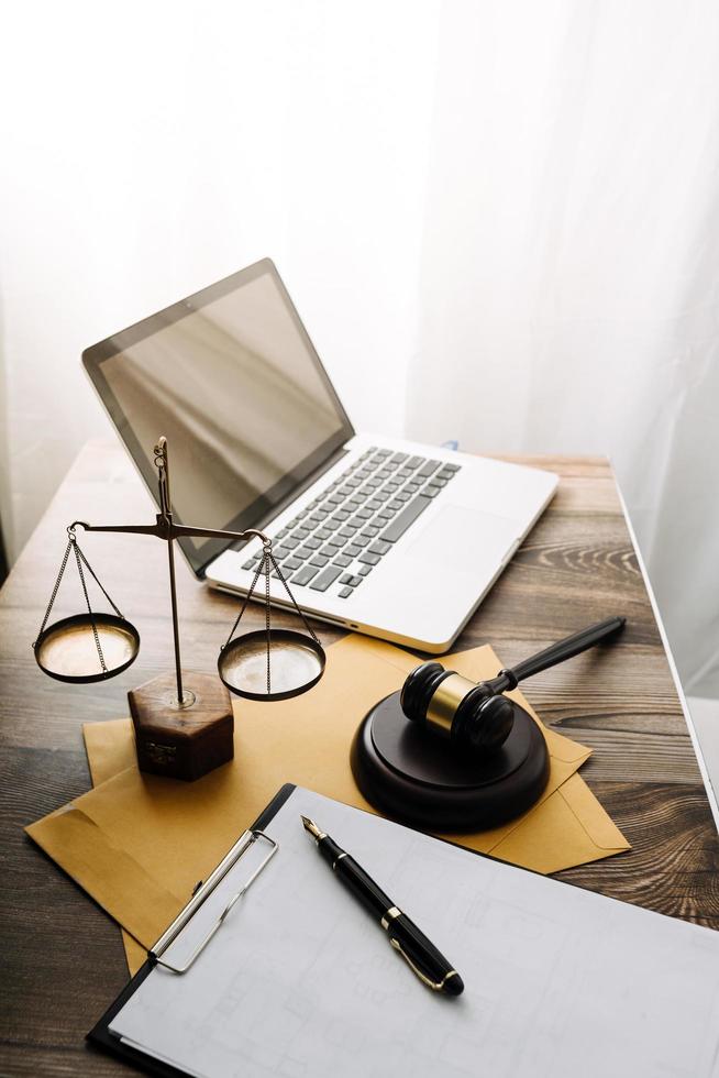 Justice and law concept.Male judge in a courtroom with the gavel, working with, computer and docking keyboard, eyeglasses, on table in morning light photo