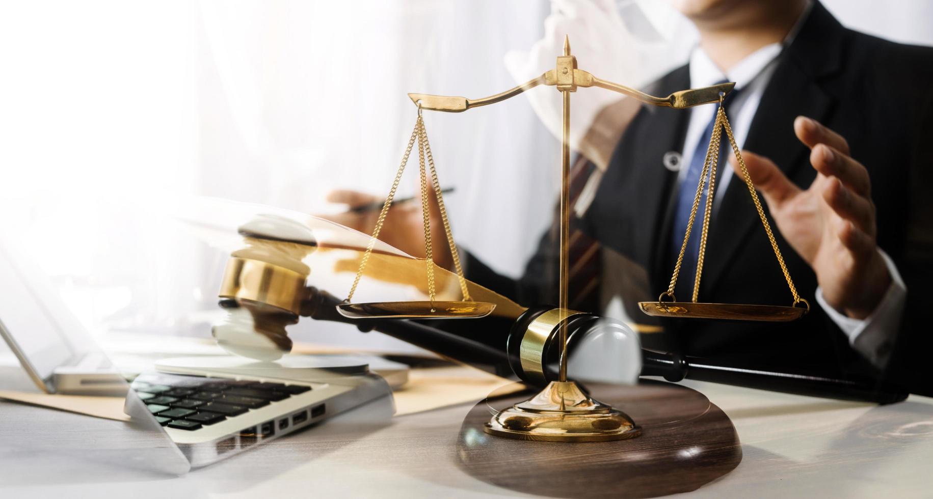 Business and lawyers discussing contract papers with brass scale on desk in office. Law, legal services, advice, justice and law concept picture with film grain effect photo