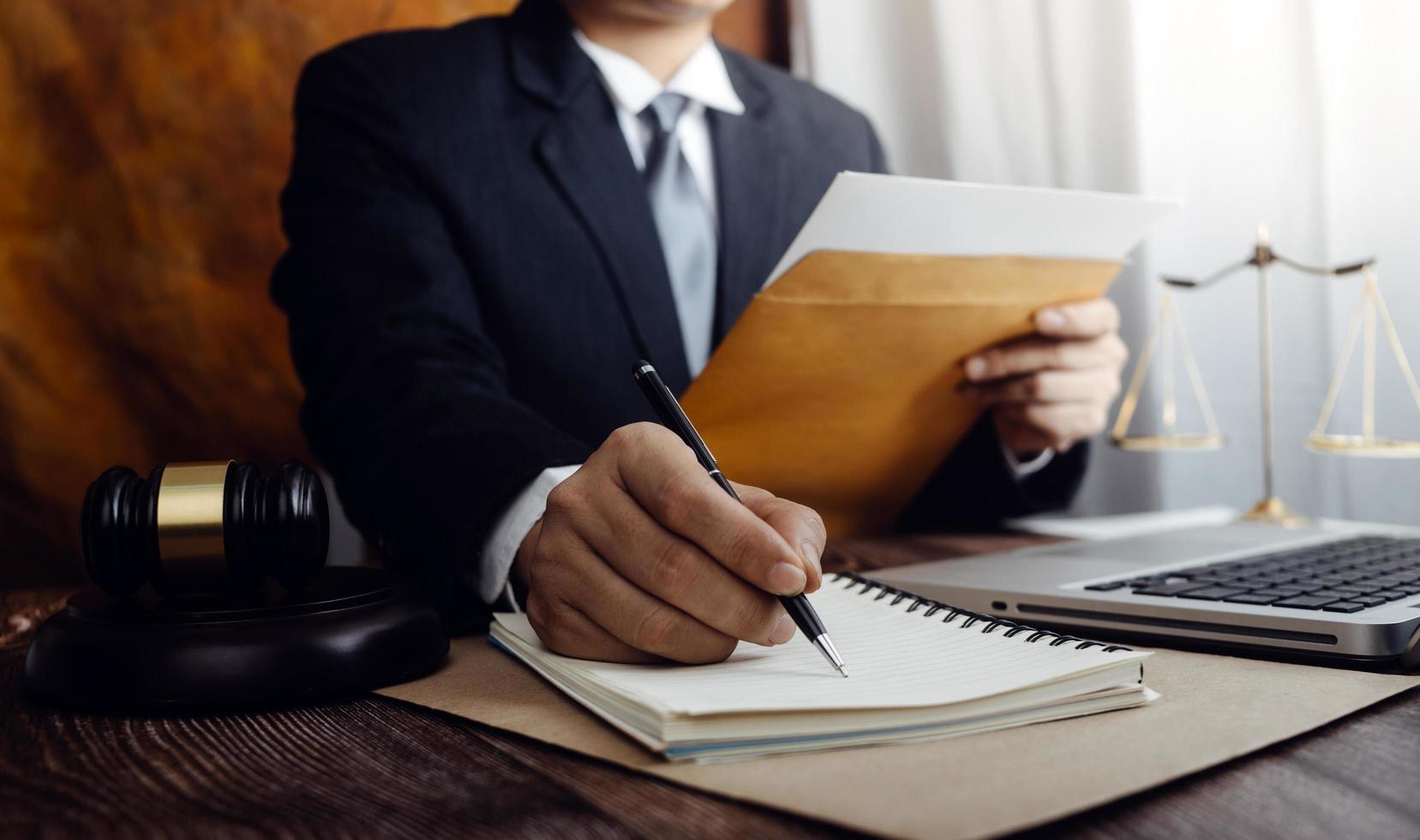 justice and law concept.Male judge in a courtroom on wooden table and Counselor or Male lawyer working in office. Legal law, advice and justice concept. photo