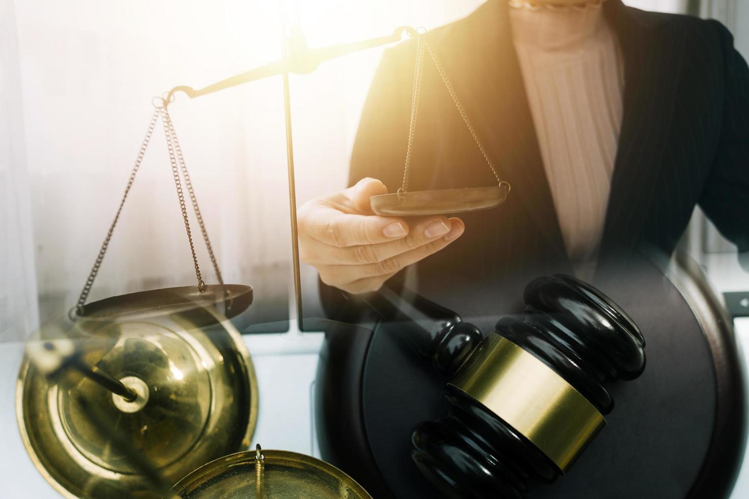 Business and lawyers discussing contract papers with brass scale on desk in office. Law, legal services, advice, justice and law concept photo