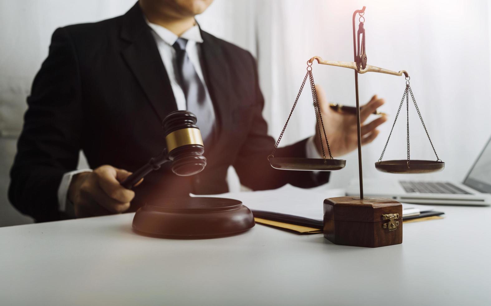 Business and lawyers discussing contract papers with brass scale on desk in office. Law, legal services, advice, justice and law concept picture with film grain effect photo