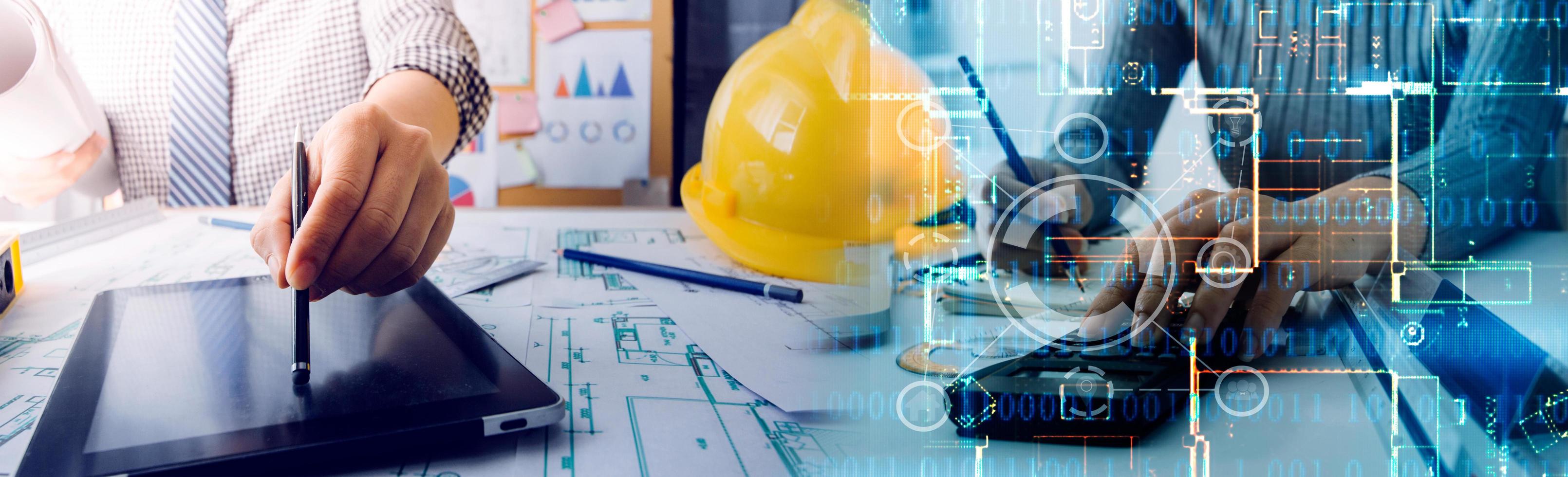 Two colleagues discussing data working and tablet, laptop with on on architectural project at construction site at desk in office photo