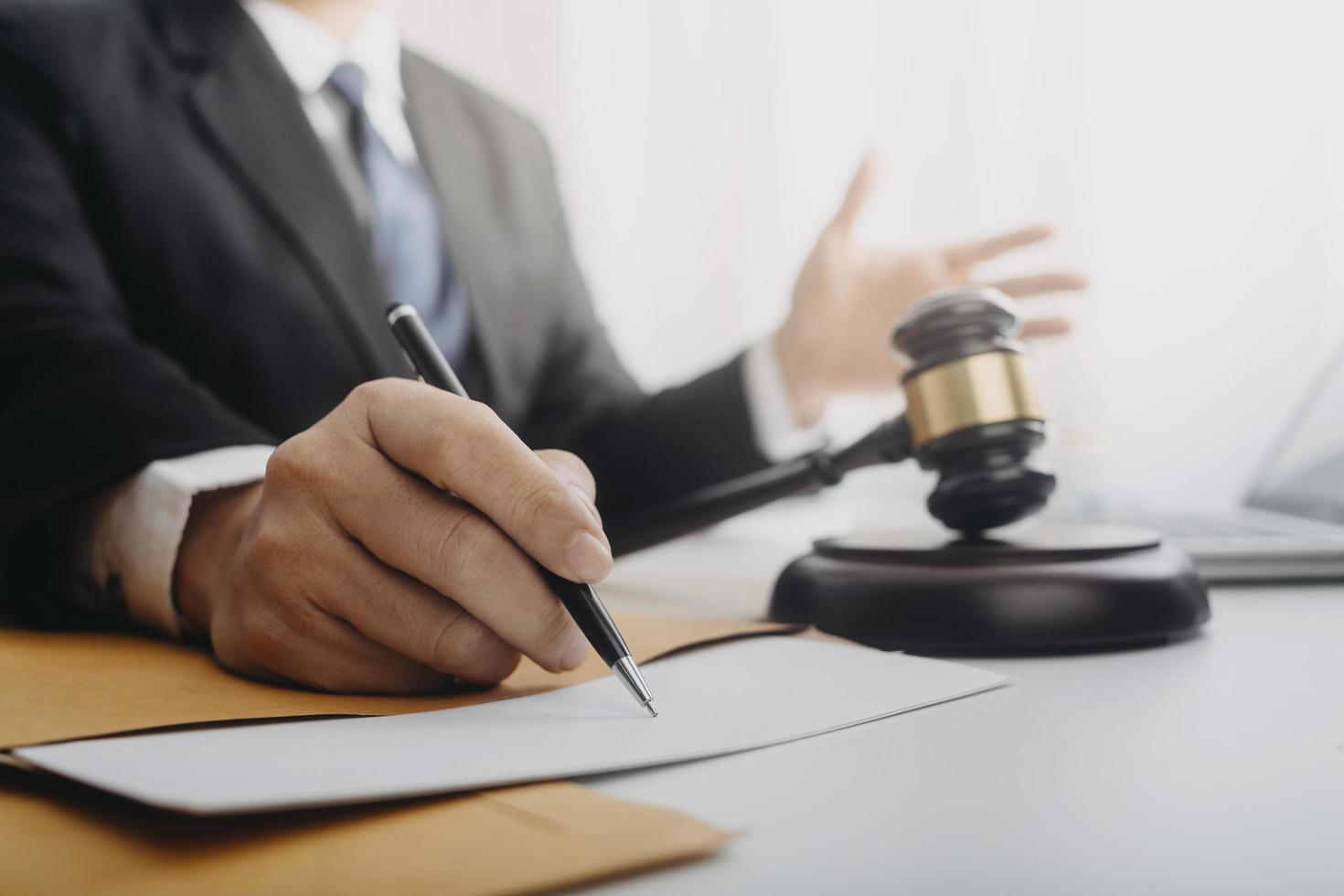 Business and lawyers discussing contract papers with brass scale on desk in office. Law, legal services, advice, justice and law concept picture with film grain effect photo