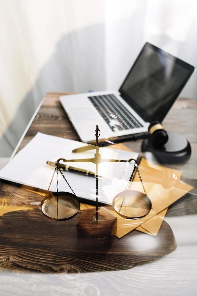 Justice and law concept.Male judge in a courtroom with the gavel, working with, computer and docking keyboard, eyeglasses, on table in morning light photo
