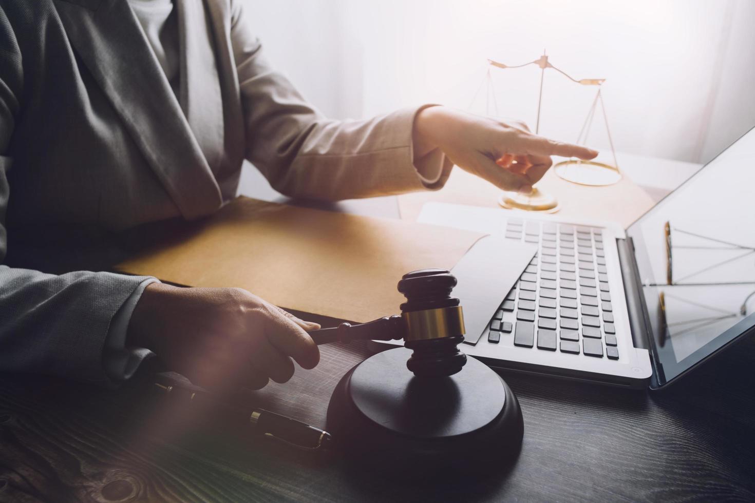 Business and lawyers discussing contract papers with brass scale on desk in office. Law, legal services, advice, justice and law concept picture with film grain effect photo