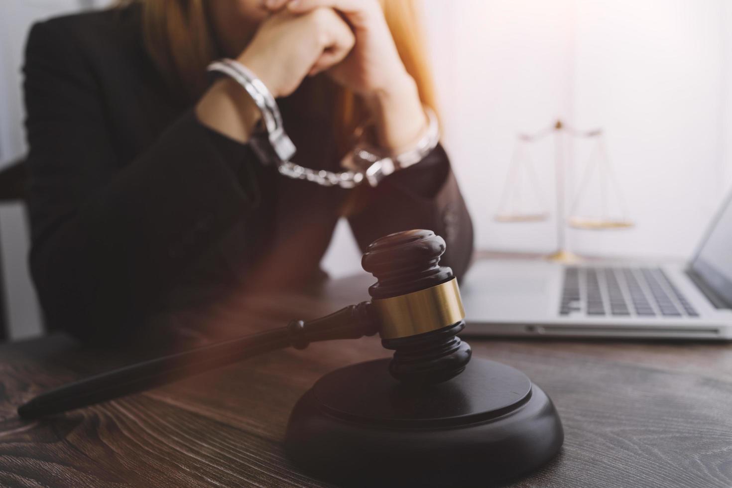 Justice and law concept.Male judge in a courtroom with the gavel, working with, computer and docking keyboard, eyeglasses, on table in morning light photo