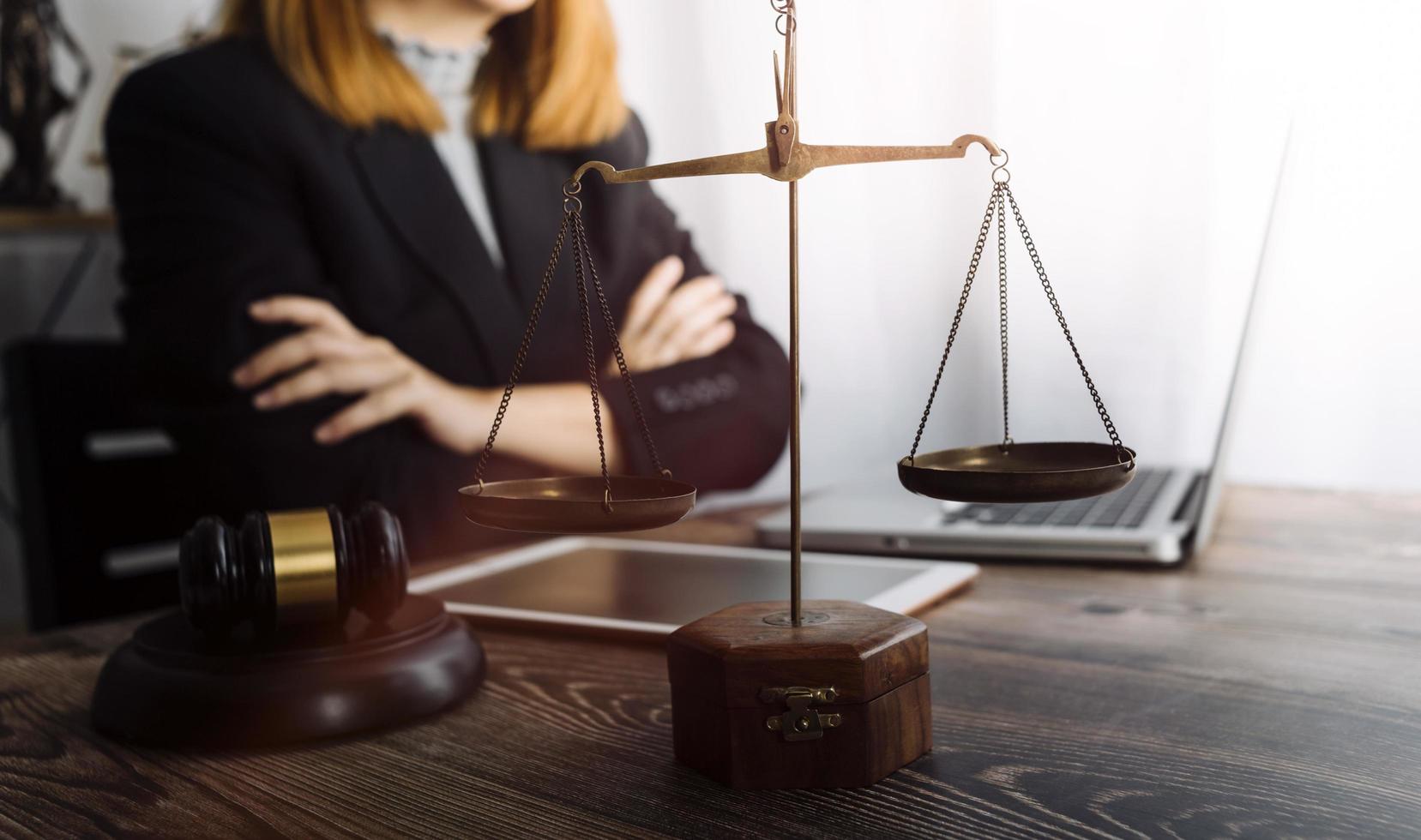 Justice and law concept.Male judge in a courtroom with the gavel, working with, computer and docking keyboard, eyeglasses, on table in morning light photo