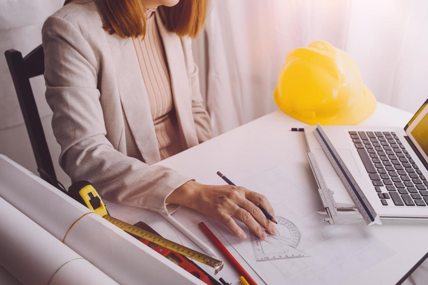 Two colleagues discussing data working and tablet, laptop with on on architectural project at construction site at desk in office photo