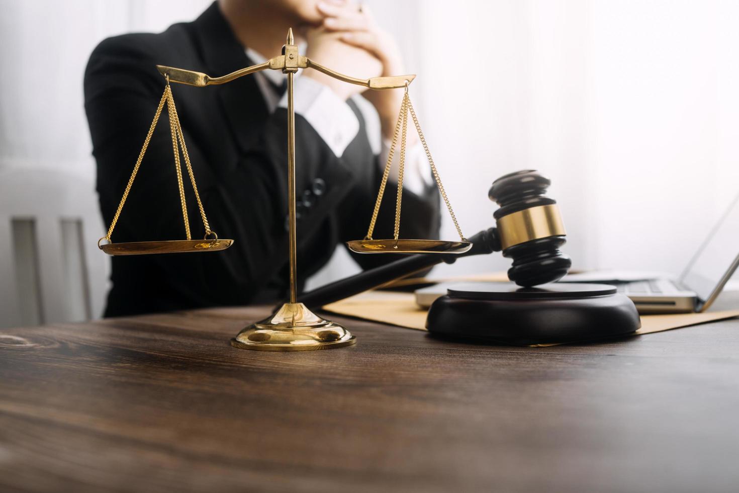 Business and lawyers discussing contract papers with brass scale on desk in office. Law, legal services, advice, justice and law concept picture with film grain effect photo