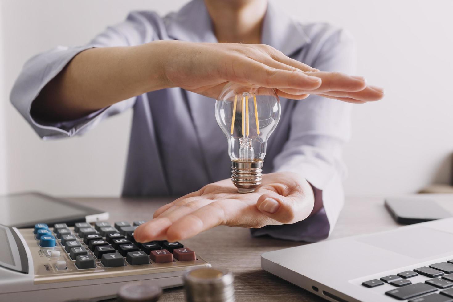 Energy saving light bulb with stacks of coins and shopping cart for saving, financial and shopping concept. photo