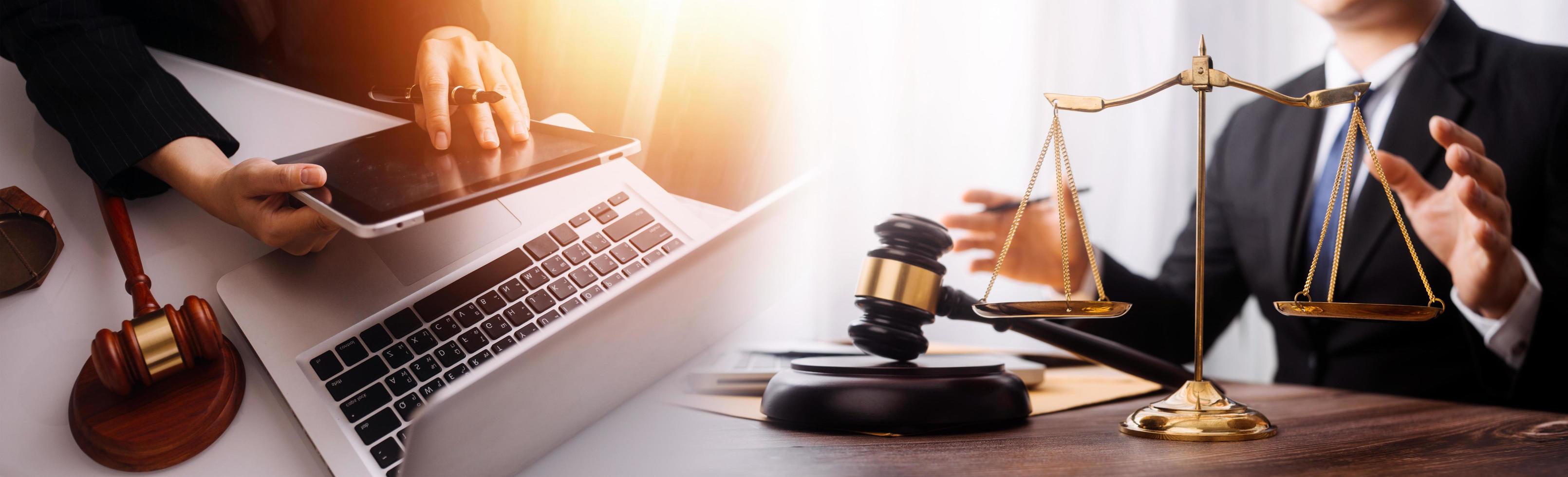 Justice and law concept.Male judge in a courtroom with the gavel, working with, computer and docking keyboard, eyeglasses, on table in morning light photo