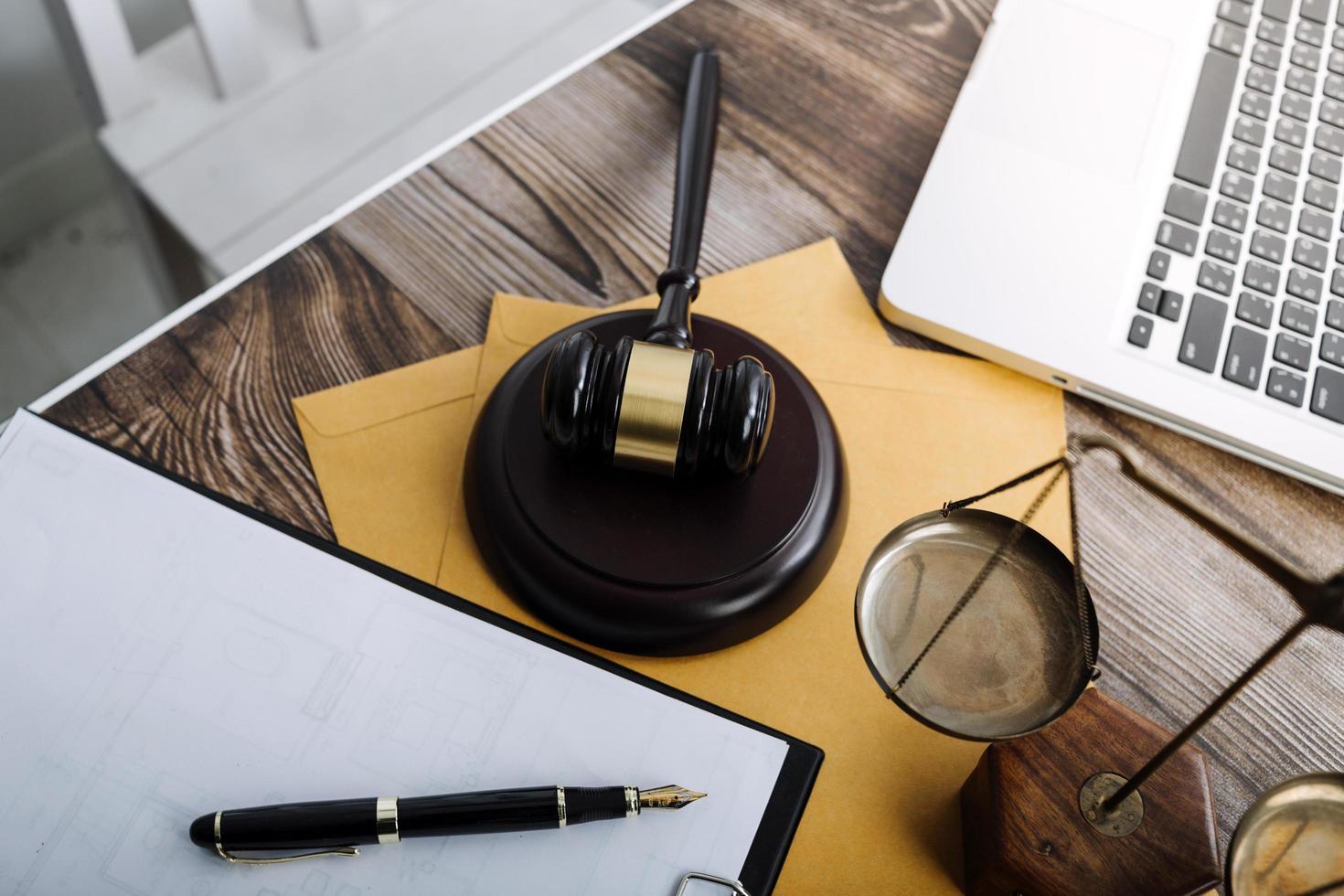 Justice and law concept.Male judge in a courtroom with the gavel, working with, computer and docking keyboard, eyeglasses, on table in morning light photo