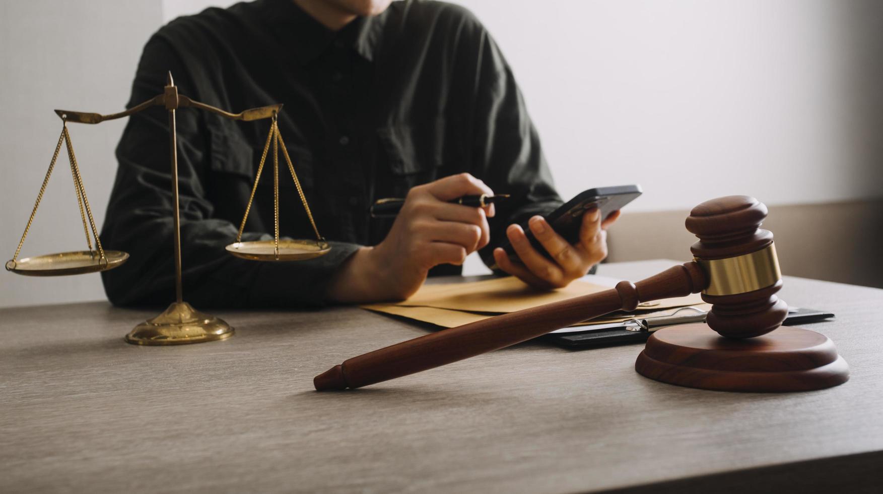 Male lawyer working with contract papers and wooden gavel on tabel in courtroom. justice and law ,attorney, court judge, concept. photo