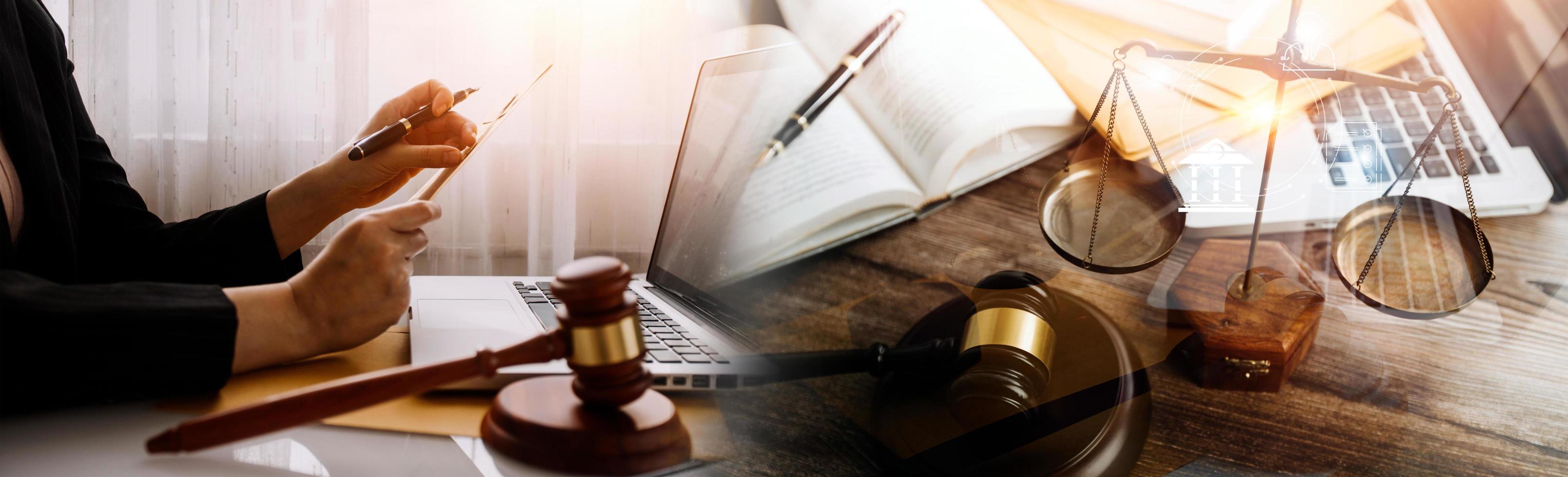 Justice and law concept.Male judge in a courtroom with the gavel, working with, computer and docking keyboard, eyeglasses, on table in morning light photo