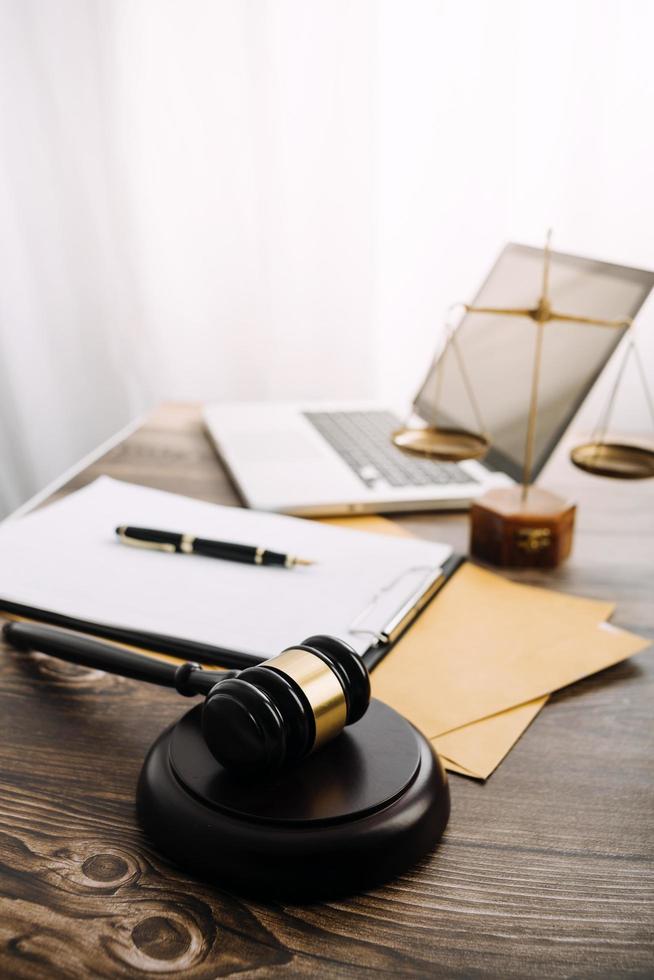 Business and lawyers discussing contract papers with brass scale on desk in office. Law, legal services, advice, justice and law concept picture with film grain effect photo