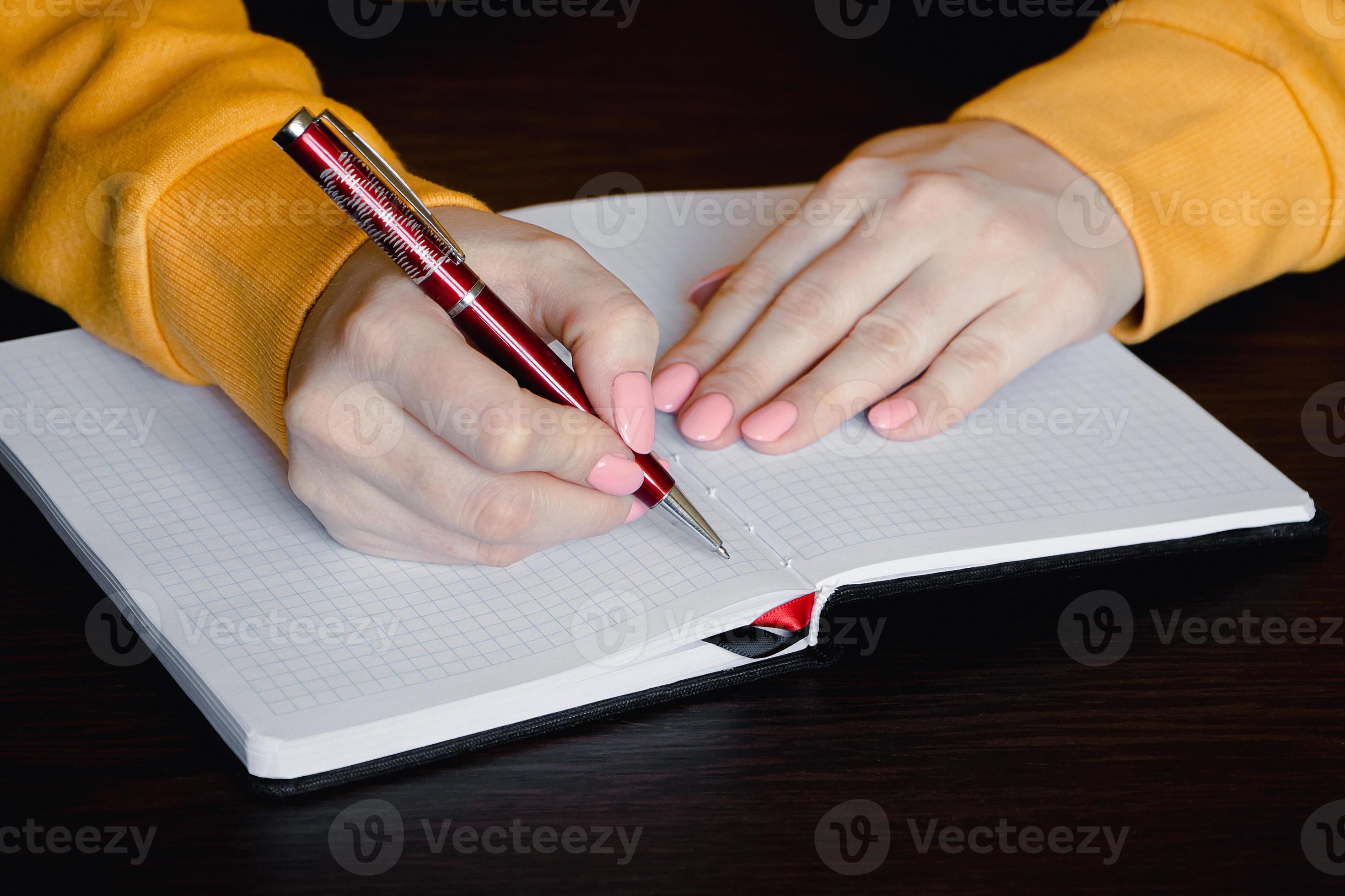 Woman writing in blank notebook. Closeup of hand holding pen. 10304923
