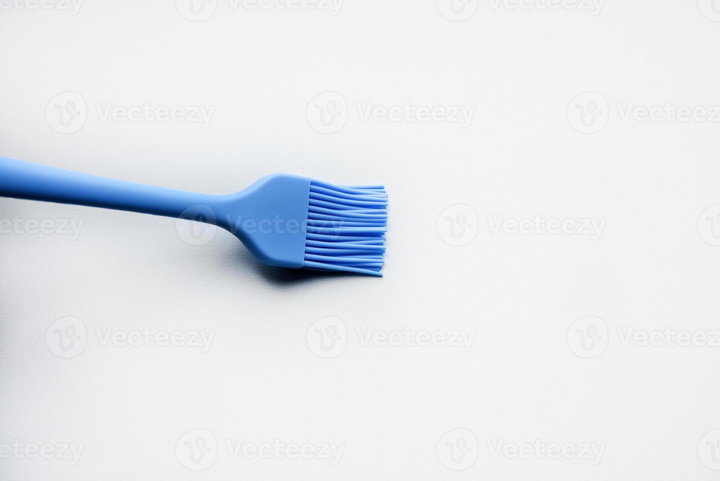 Blue plastic brush for smearing sunflower oil on a frying pan. A device for smearing oil. photo