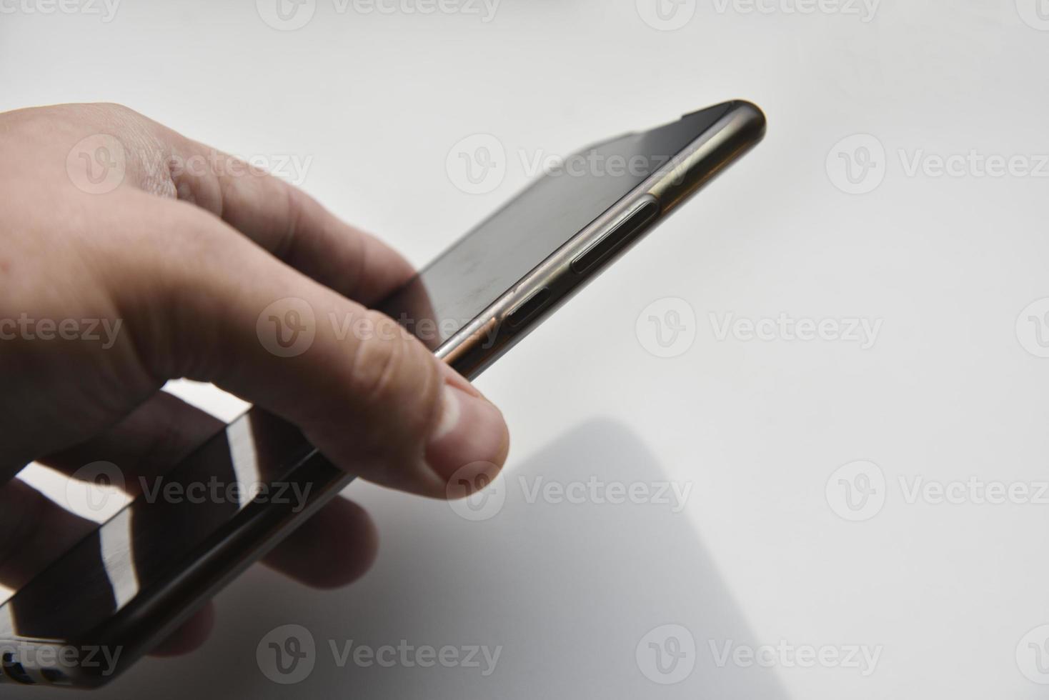 teléfono inteligente negro en la mano sobre un fondo blanco. foto