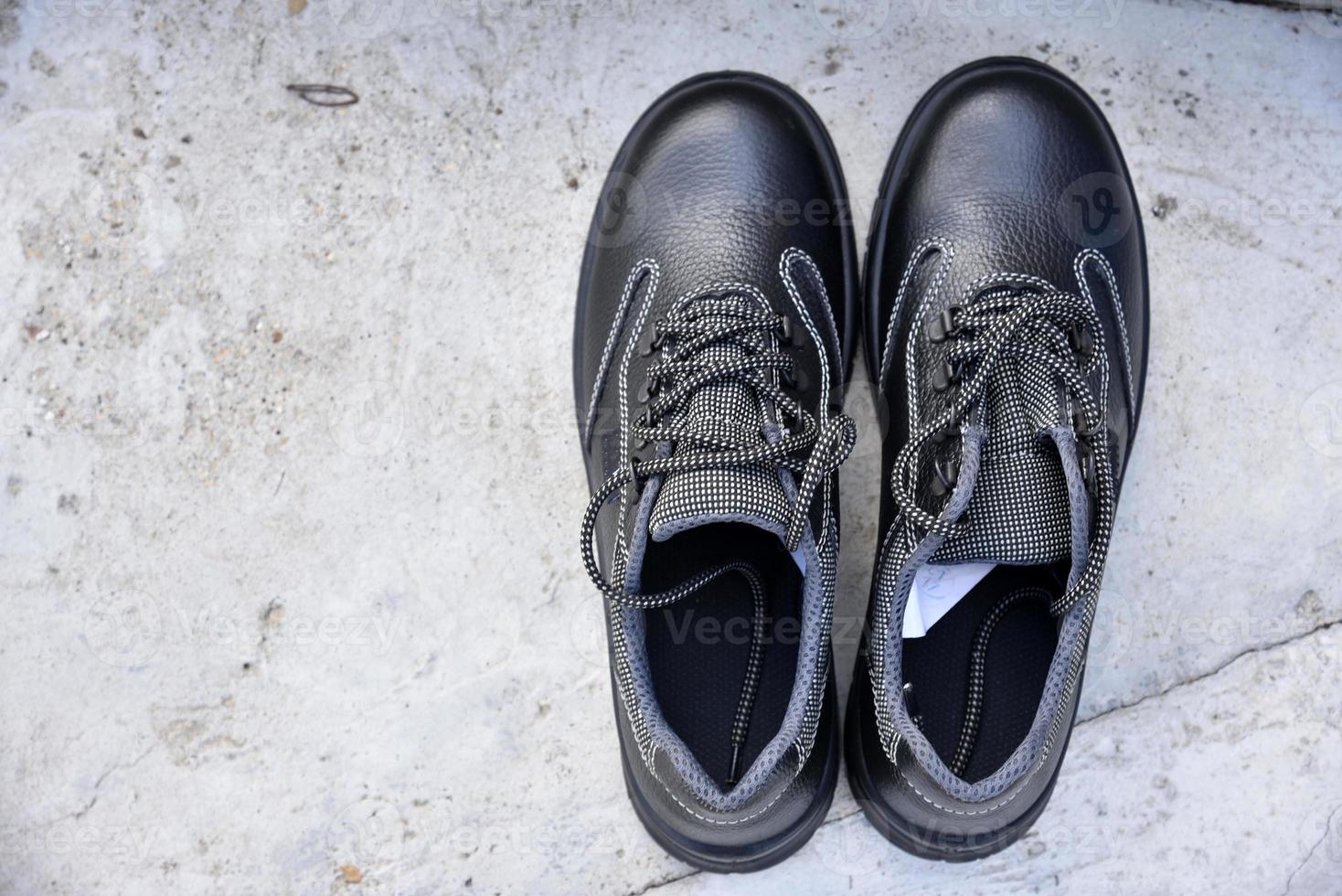 Black new work boots on the street during the day. photo