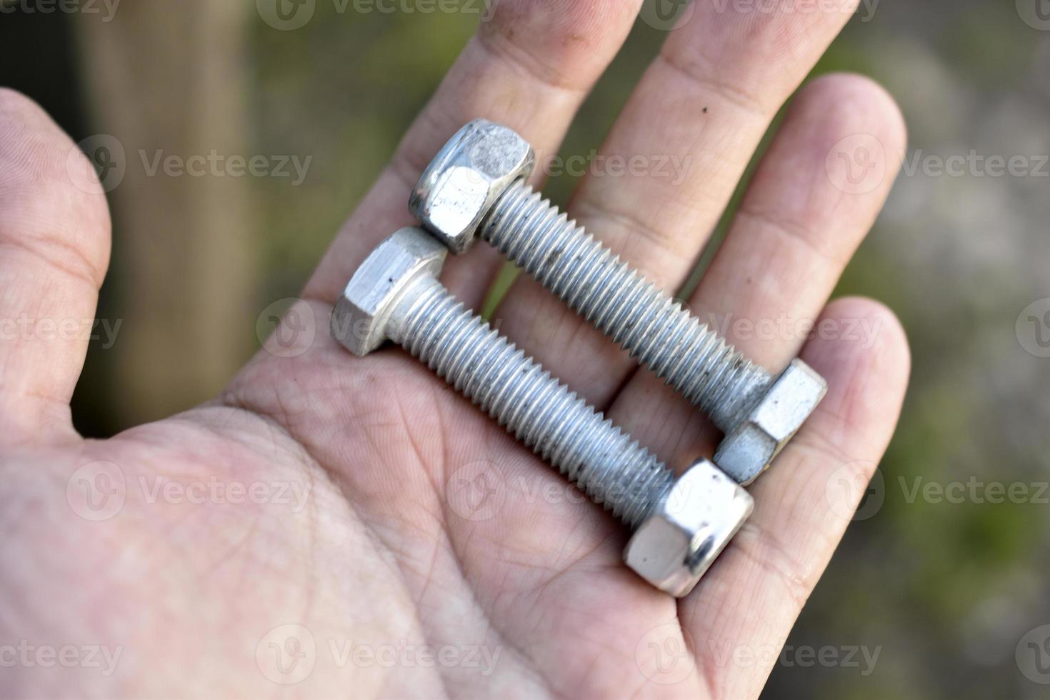 Iron shiny bolts dirty in the palm of your hand photo