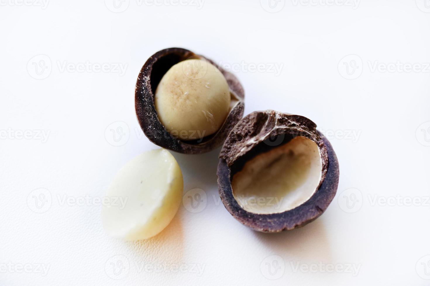 Whole nut and Macadamia kernel on a white background. Delicious whole nuts. photo