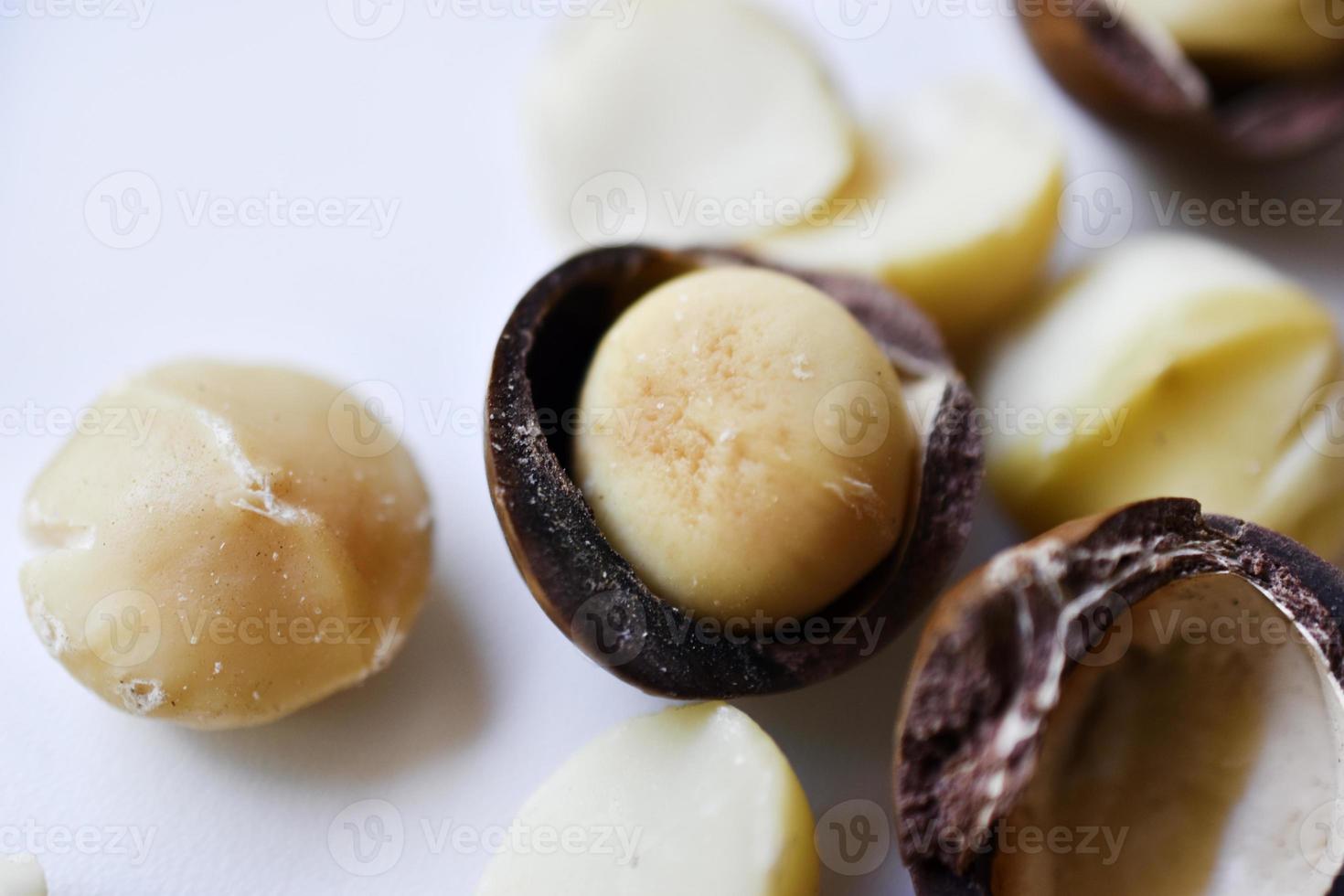 Whole nut and Macadamia kernel on a white background. Delicious whole nuts. photo