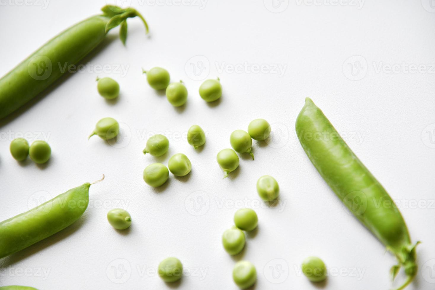 Pods of fresh green peas and green scattered peas. photo