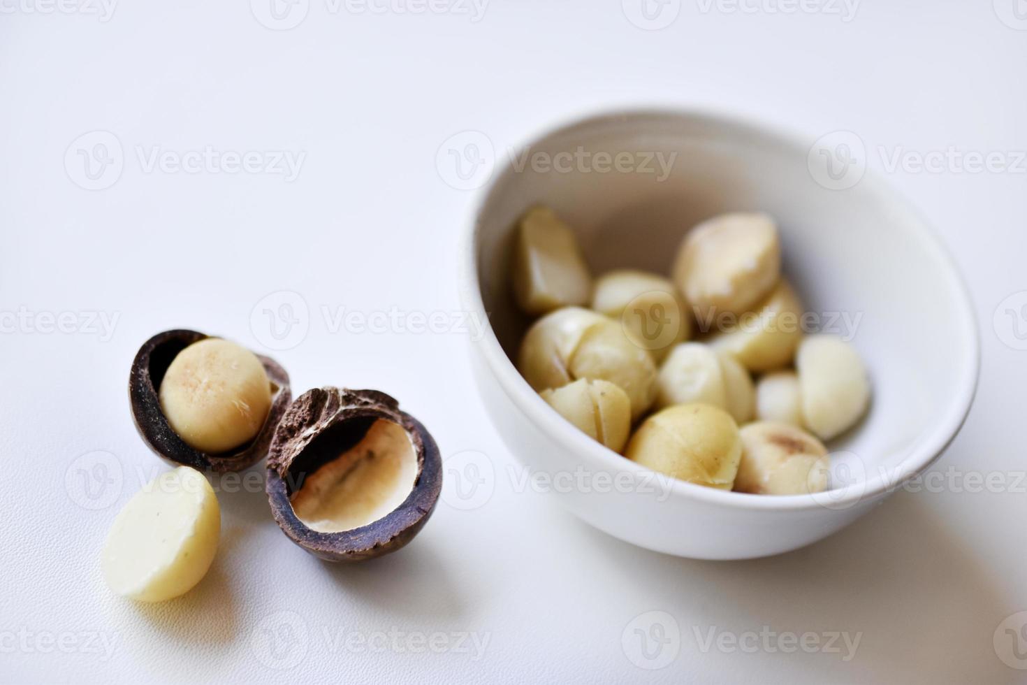 Whole nut and Macadamia kernel on a white background. Delicious whole nuts. photo