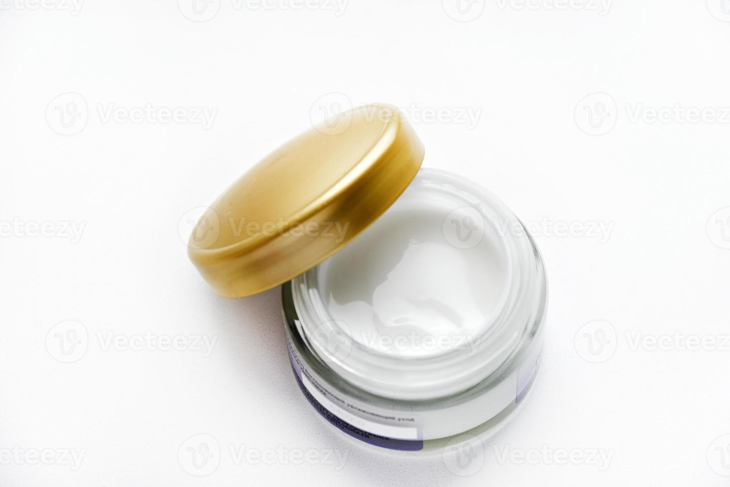 A jar of face cream on a white background. Night cream and hand close-up. photo