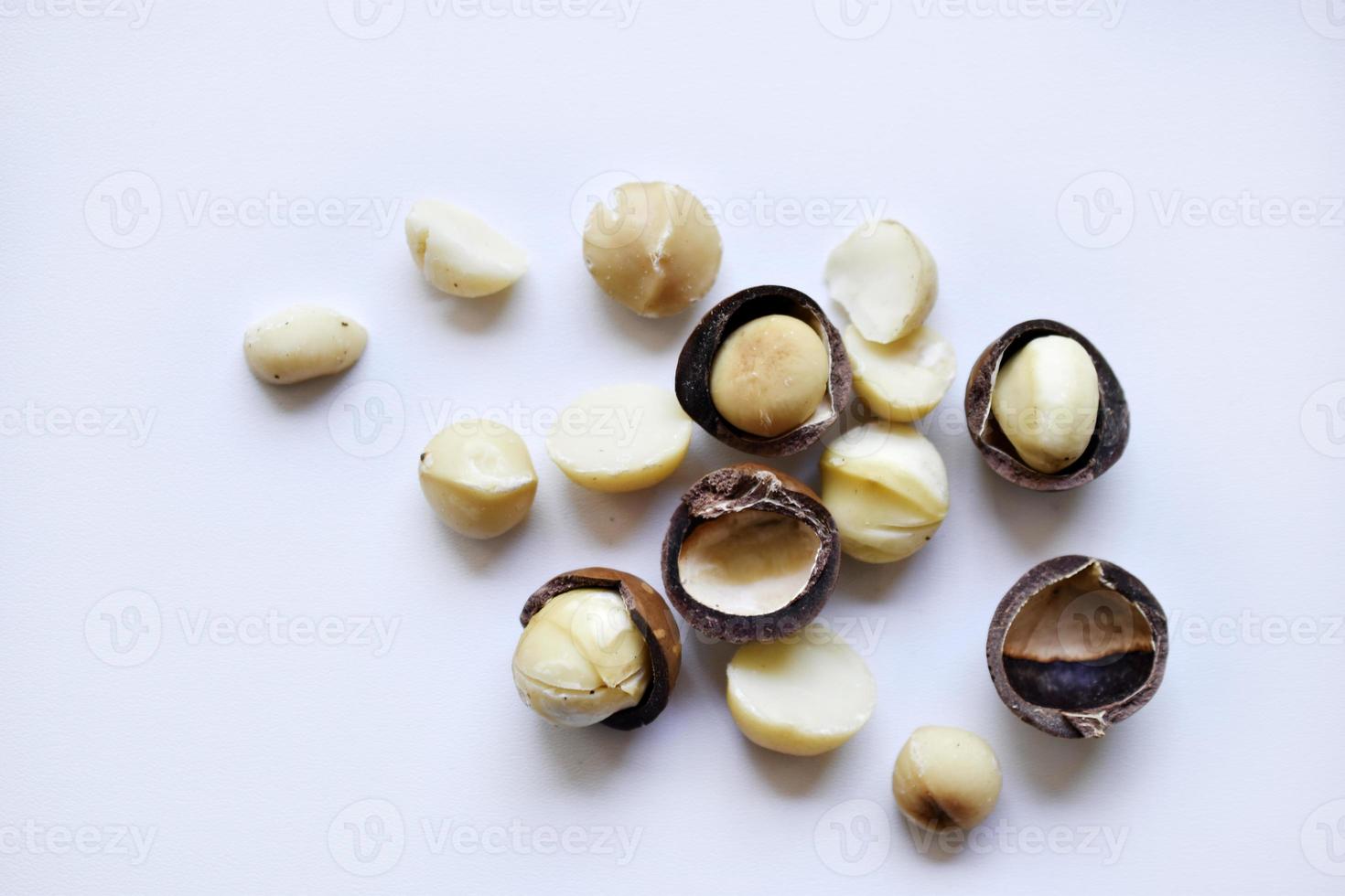 Whole nut and Macadamia kernel on a white background. Delicious whole nuts. photo