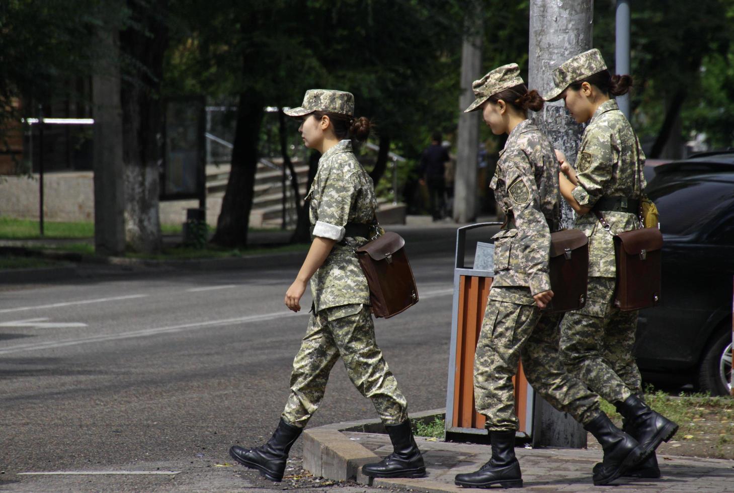 almaty, kazajstán - 24 de agosto de 2019 - tres mujeres uniformadas cruzando una calle en almaty. foto