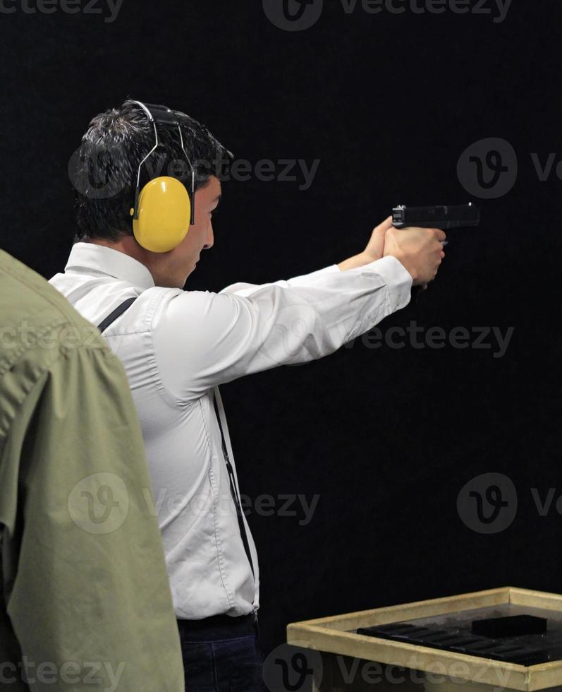 Young man with a gun at a shooting range photo
