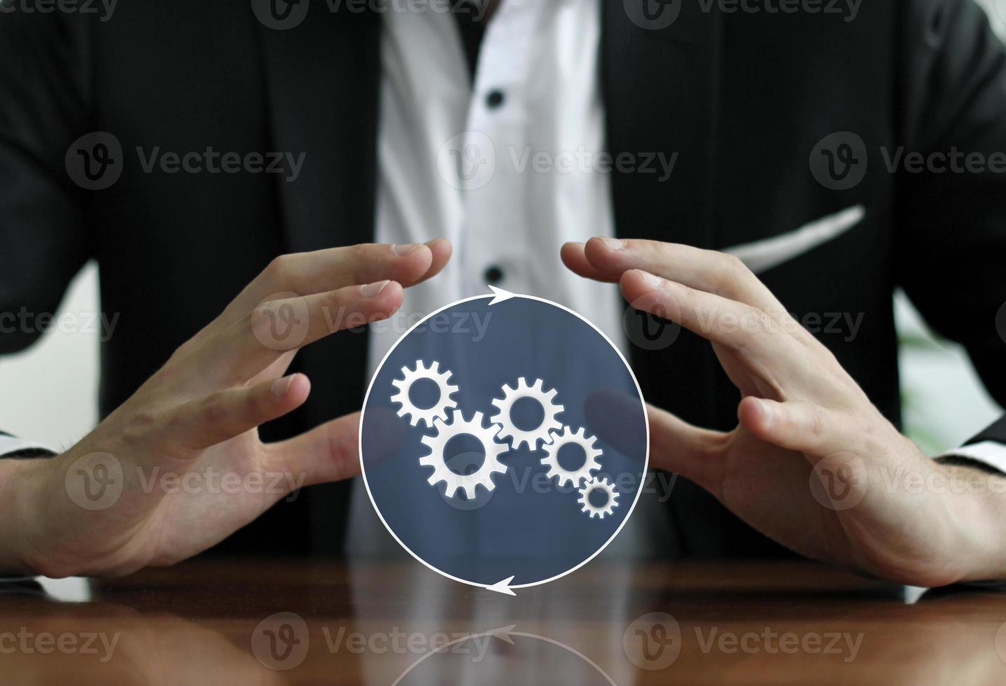 Businessman and integrated services - man protecting gears with his hands photo