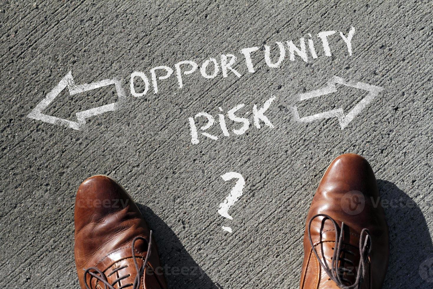 Top view on a man standing in front of the words Risk and Opportunity with arrows pointing to the left and right side of the picture photo