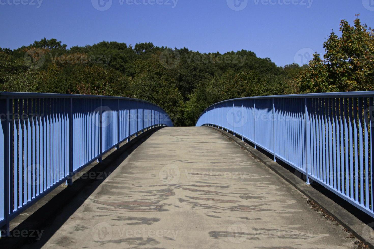 A clear path ahead - symmetrical view of a pedestrian bridge into a forest photo