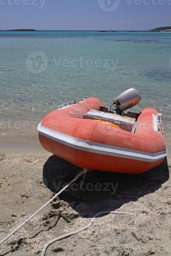 Red boat in front of the clear water at Elafonisi, Crete, Greece photo