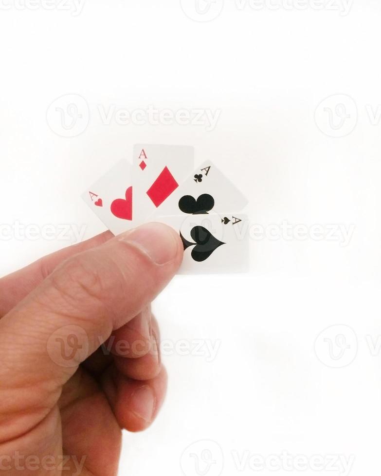 Man holding a up four tiny playing card aces photo