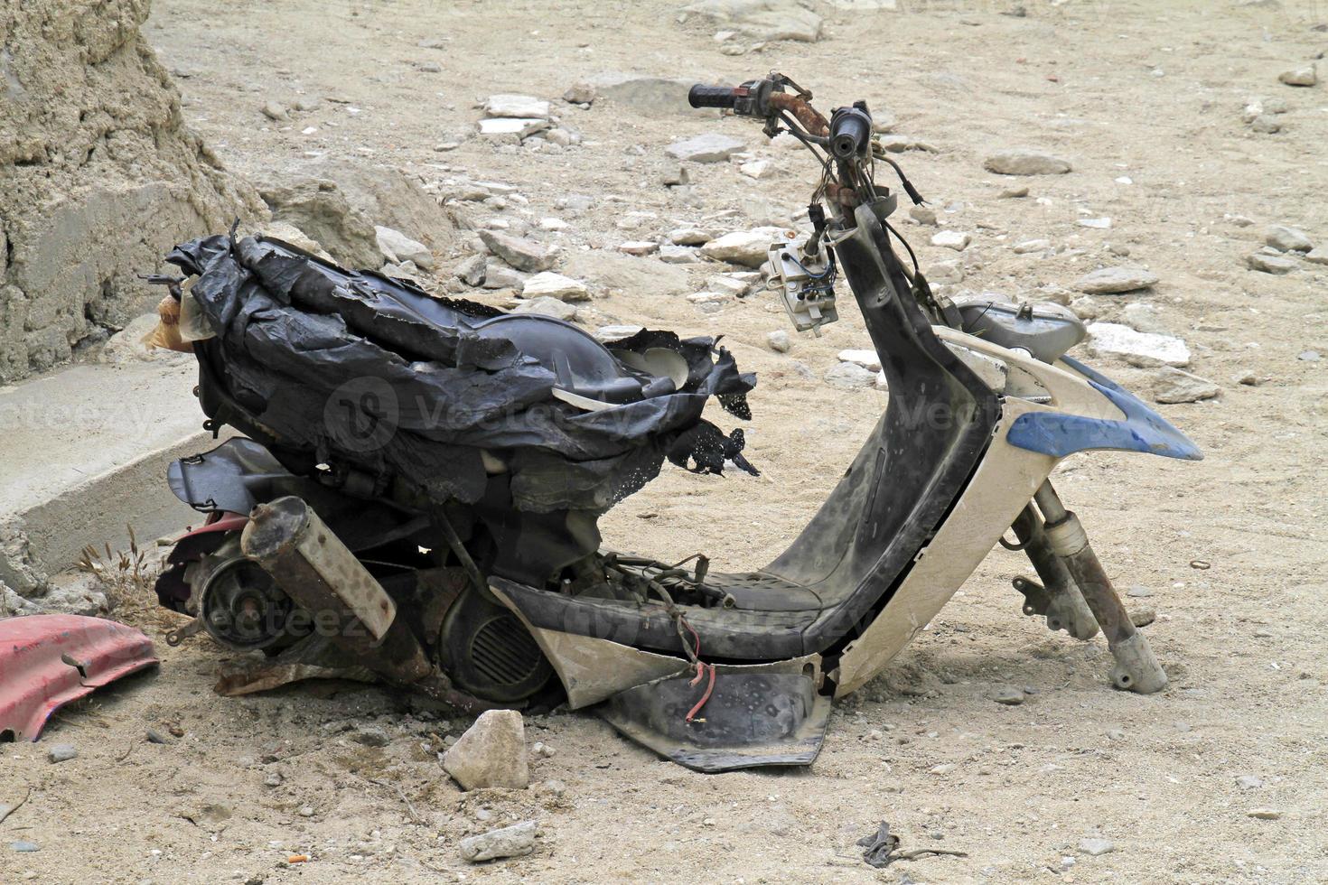 Heavily damaged scooter abandoned on a parking lot photo