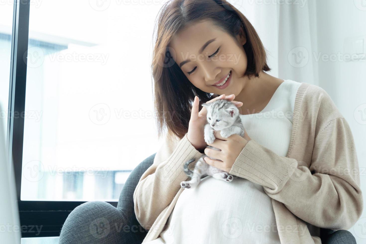 Portrait of young Asian pregnant with kitten photo