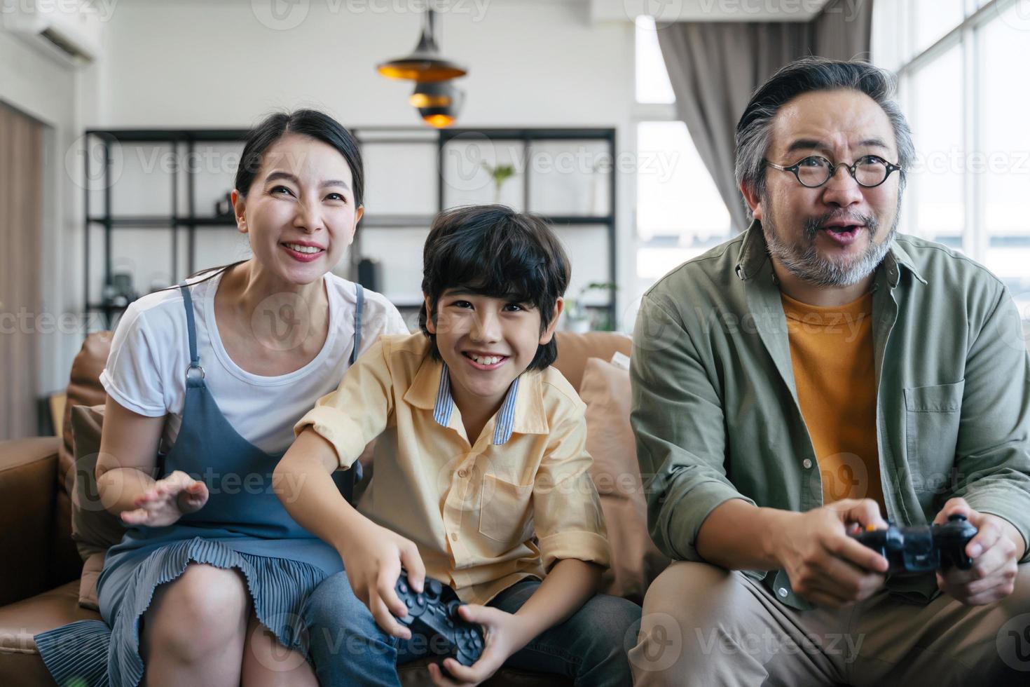 familia asiática jugando videojuegos en casa foto
