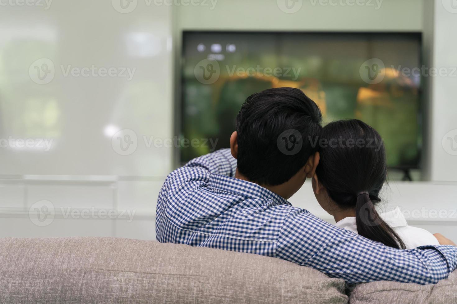 couple watching television at home photo