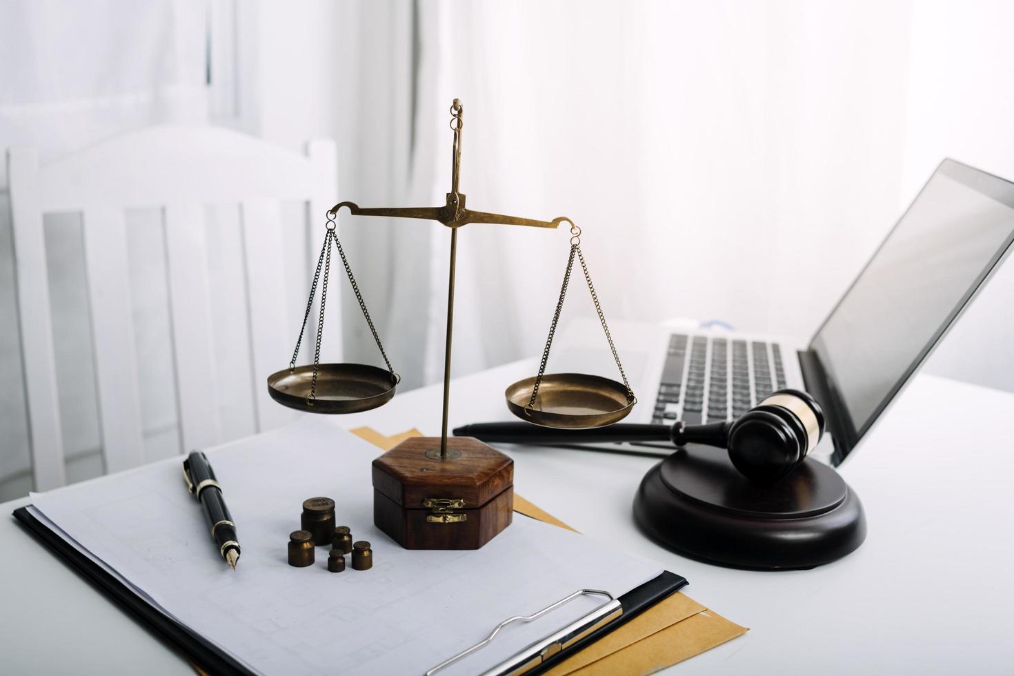 Justice and law concept.Male judge in a courtroom with the gavel, working with, computer and docking keyboard, eyeglasses, on table in morning light photo