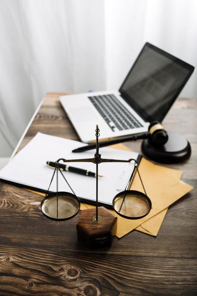 Justice and law concept.Male judge in a courtroom with the gavel, working with, computer and docking keyboard, eyeglasses, on table in morning light photo