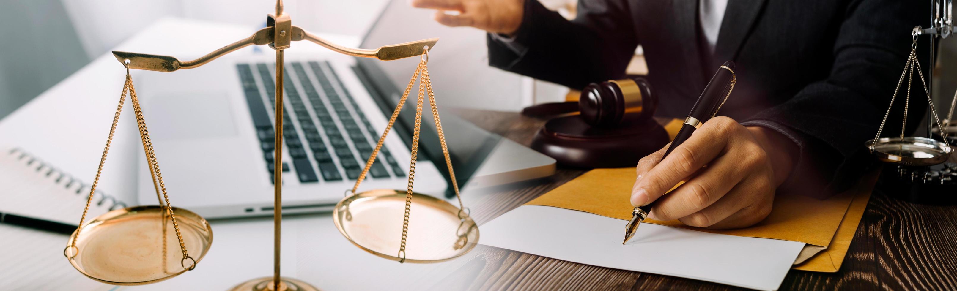 Justice and law concept.Male judge in a courtroom with the gavel, working with, computer and docking keyboard, eyeglasses, on table in morning light photo