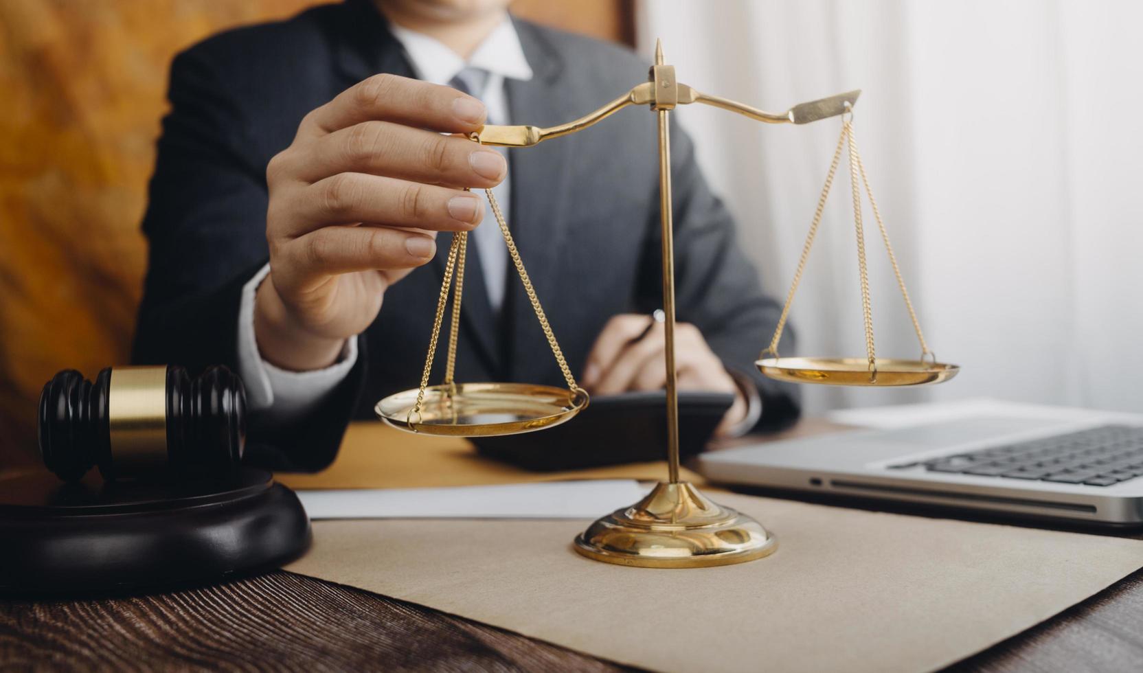 Business and lawyers discussing contract papers with brass scale on desk in office. Law, legal services, advice, justice and law concept picture with film grain effect photo