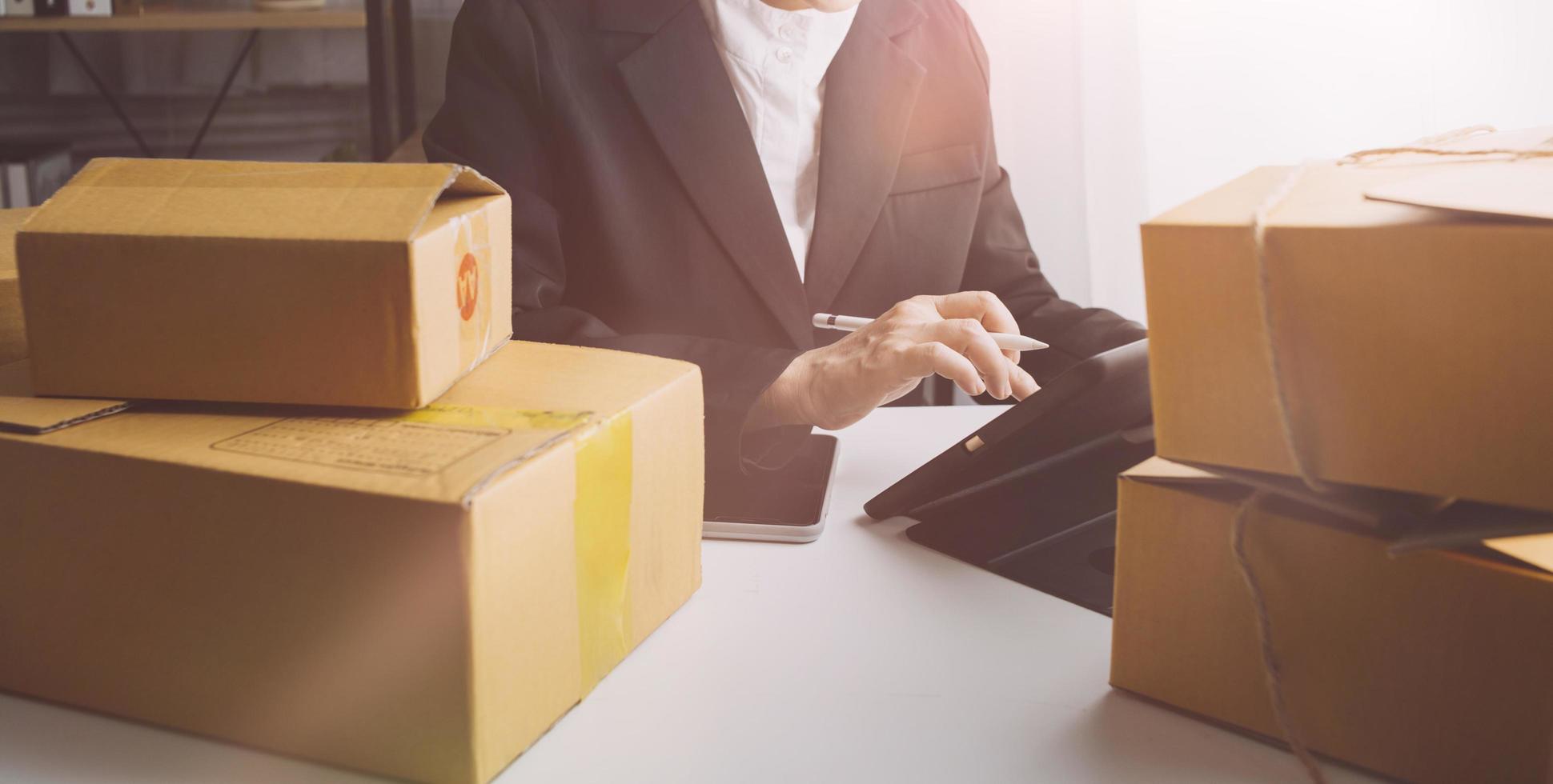 Business woman start up small business entrepreneur SME success .freelance woman working at home with Online Parcel delivery. SME and packaging deliveryconcept photo